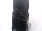 a broken cell phone sitting on a stand on a table