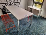 a white table and orange chairs in a room