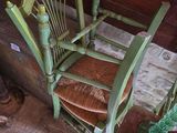 a green rocking chair sitting in the corner of a room