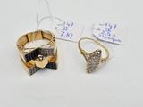 two rings and a ring with a bow tie on a white surface