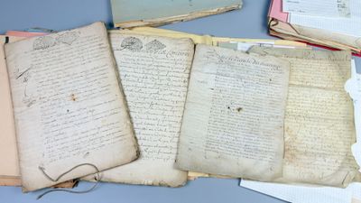 several old papers are stacked on top of each other on a table