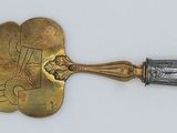 a gold and silver trowet laying on a white surface