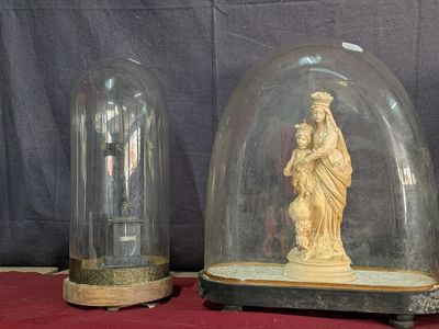 deux dômes en verre contenant des statues, posés sur une table