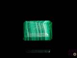 a close up of a green emerald stone on a black background