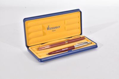 deux stylos dans un étui bleu posés sur une surface blanche