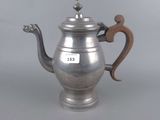 an antique silver teapot with a wooden handle on a grey background