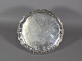 a close up of a silver plate on a gray surface