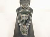 une image représentant une statue d'une femme avec un chat sur les genoux