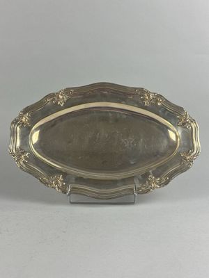 an antique silver plate with a decorative design on it