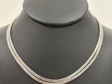 a white gold necklace with two rows of diamonds on a mannequin