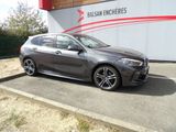 La BMW M140i M Sport Break est garée devant un immeuble