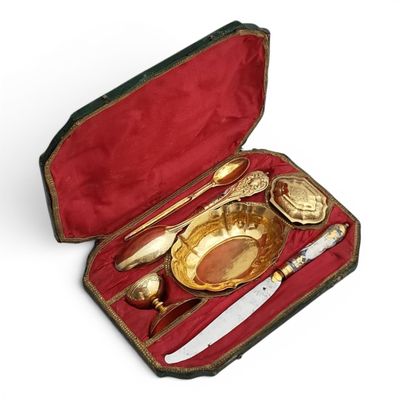 un plateau en or et des couverts en argent dans un coffret rouge