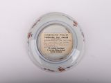 a small plate with a label on it on a white surface