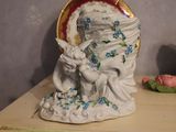 a figurine of a woman holding a baby on a shelf