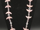 un collier composé de perles roses et blanches sur un mannequin noir