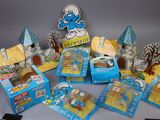 assortment of smurfes and other toys on display on a table