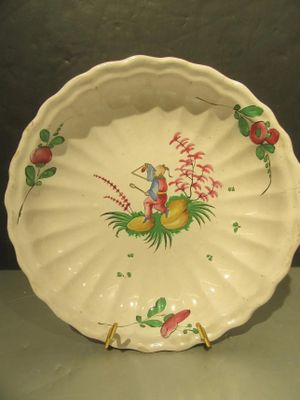 une assiette blanche sur laquelle est représenté un homme et un oiseau