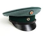 a green hat on a black base on a white surface