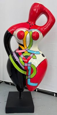 un vase coloré posé sur un socle noir au sol