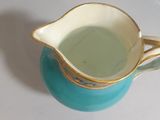 a blue and white pitcher with a gold rim