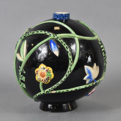 une image représentant un vase noir orné de fleurs