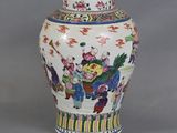 a vase with a painting on it sitting on a table