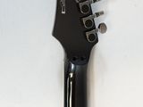 a close up of an electric guitar on a white surface