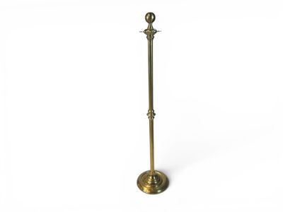 a brass plated floor lamp with a glass shade