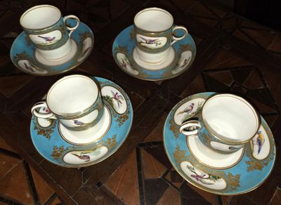 quatre tasses et soucoupes posées sur une table