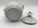 a small white vase with a bird on it