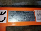 a close up of a metal sign on an orange bench
