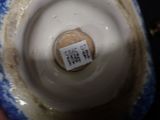 a close up of a blue and white vase with a label on it