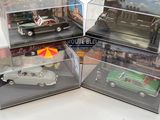 quatre modèles réduits de voitures dans une vitrine posée sur une table