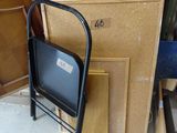 une chaise noire posée devant une pile de bois