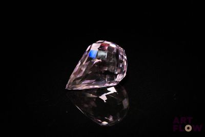 a close up of a pink diamond on a black surface