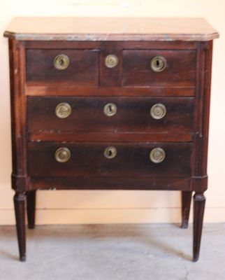 une commode en bois ornée de boutons en laiton