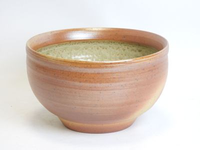 a brown bowl that has a green substance in it