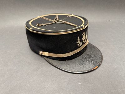 un chapeau noir orné d'une bordure dorée sur fond gris