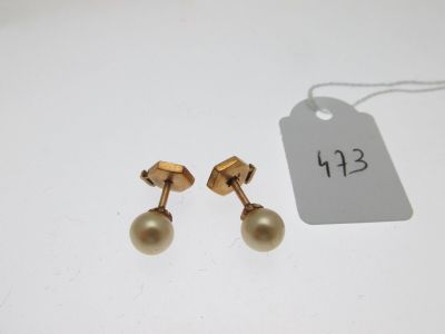 une paire de boucles d'oreilles en or ornées de perles, avec son étiquette de prix