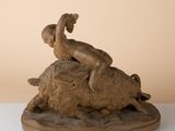 statue of a woman sitting on top of a boar on a white surface