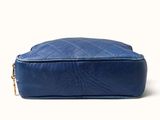 the large blue bag is sitting on a white surface