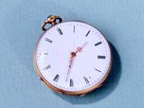 une montre de poche en or avec des chiffres romains sur le cadran