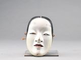 une photo d'une sculpture représentant le visage d'une femme, posée sur un socle