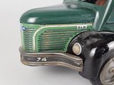 a green toy truck that is sitting on a white surface
