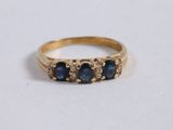 a close up of a gold ring with three sapphire stones