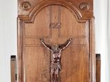 une statue de Jésus sur la croix, posée sur un socle en bois