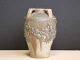 a vase that is sitting on a table in front of a wall