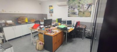 an image of an office with a lot of clutter on the desk