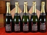 six bottles of champagne sitting on top of a table next to boxes