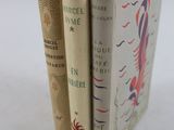 trois livres sont empilés sur une surface blanche